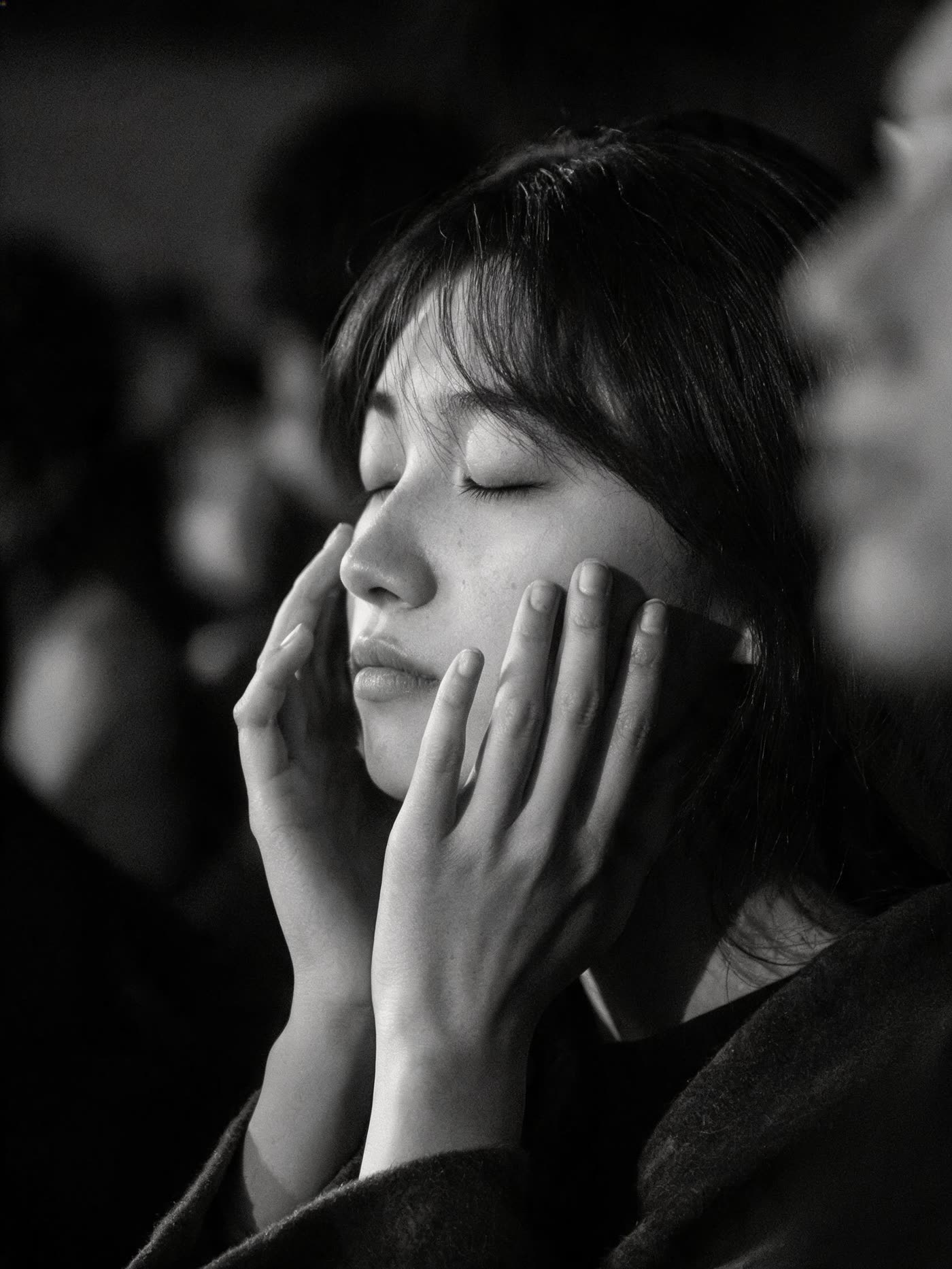 A person with eyes closed in quiet prayer during a gathering